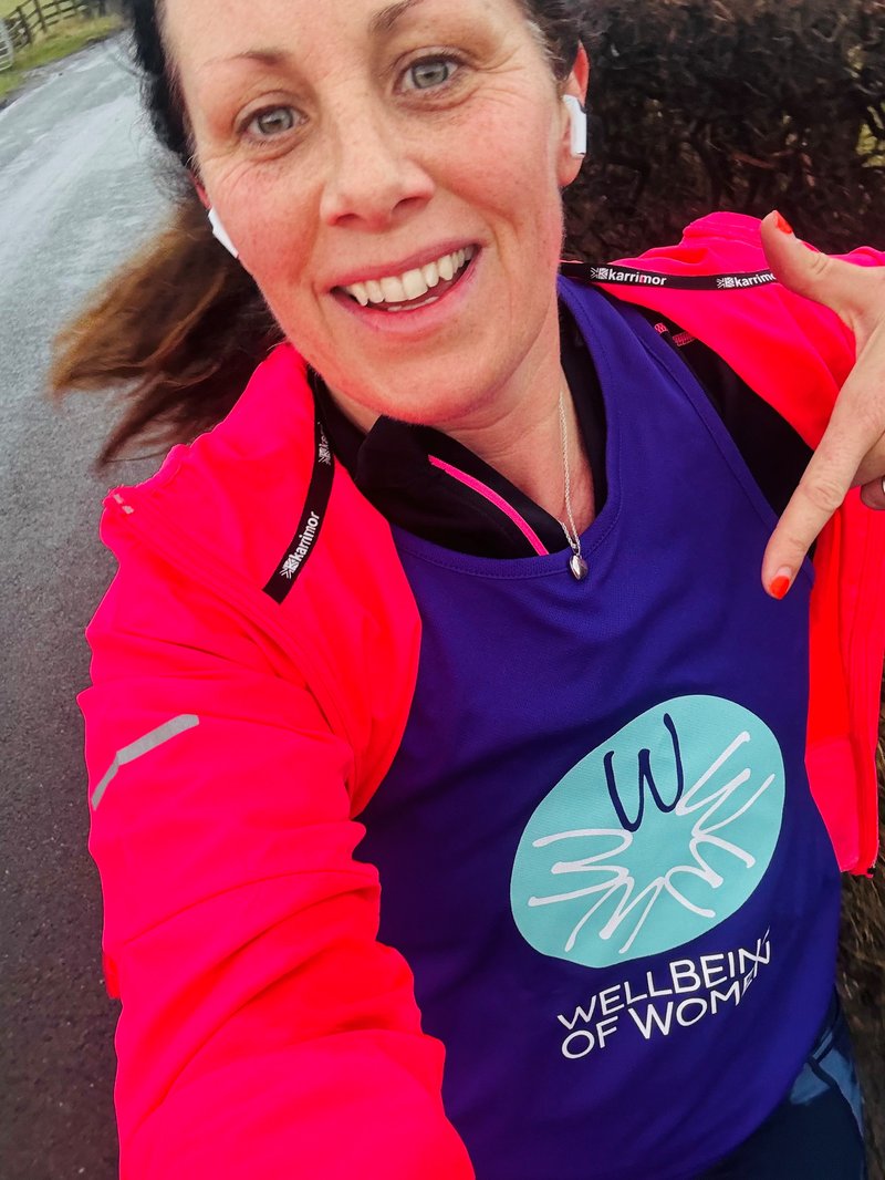 Anna running in a Wellbeing of Women Vest