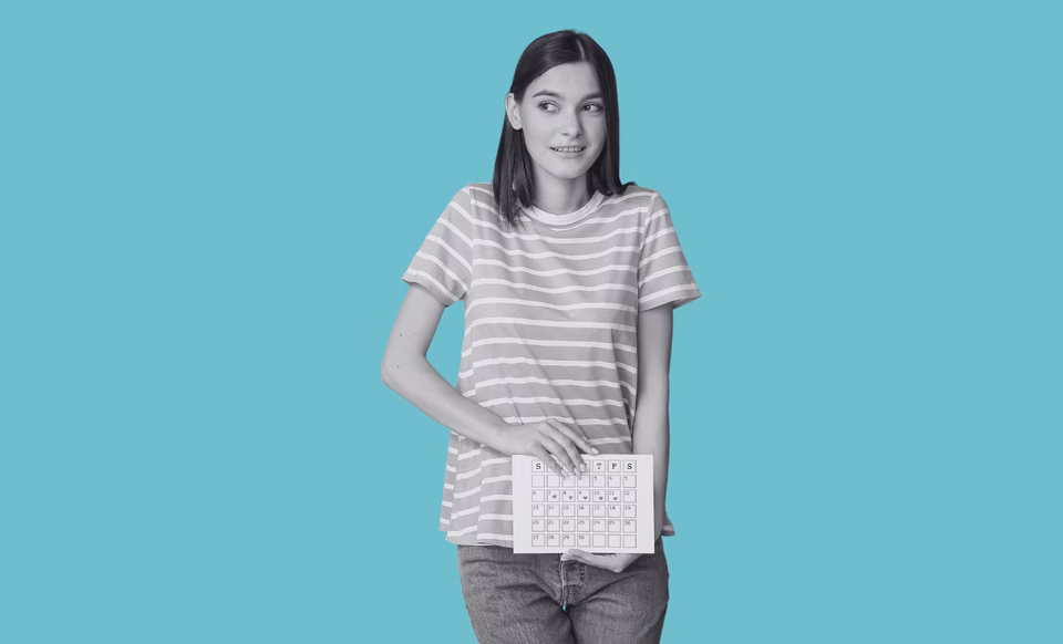 A teenager holding a menstrual calendar looking confused.