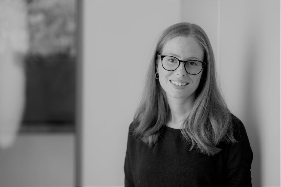 A black and white image of Wellbeing of Women researcher Rebecca Blaylock smiling