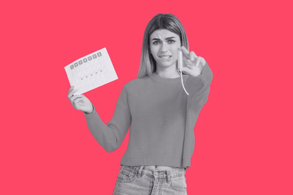 A teenager holding a menstrual calendar and tampon looking ocnfused.