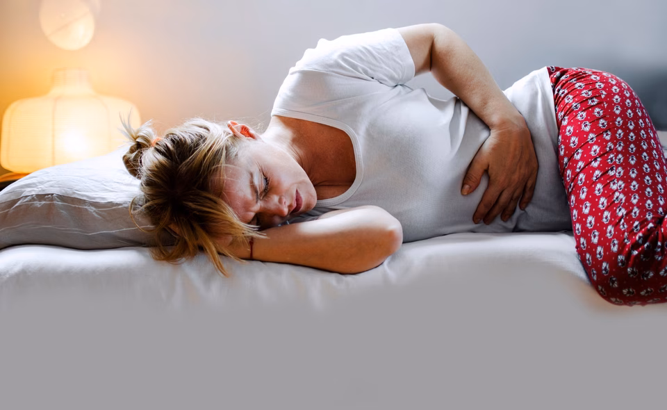 White woman holding stomach in pain