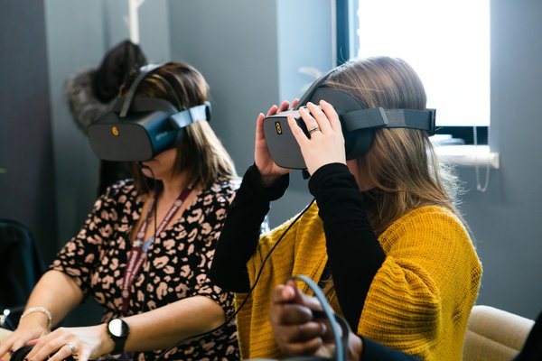 Two women with a VR headset on them